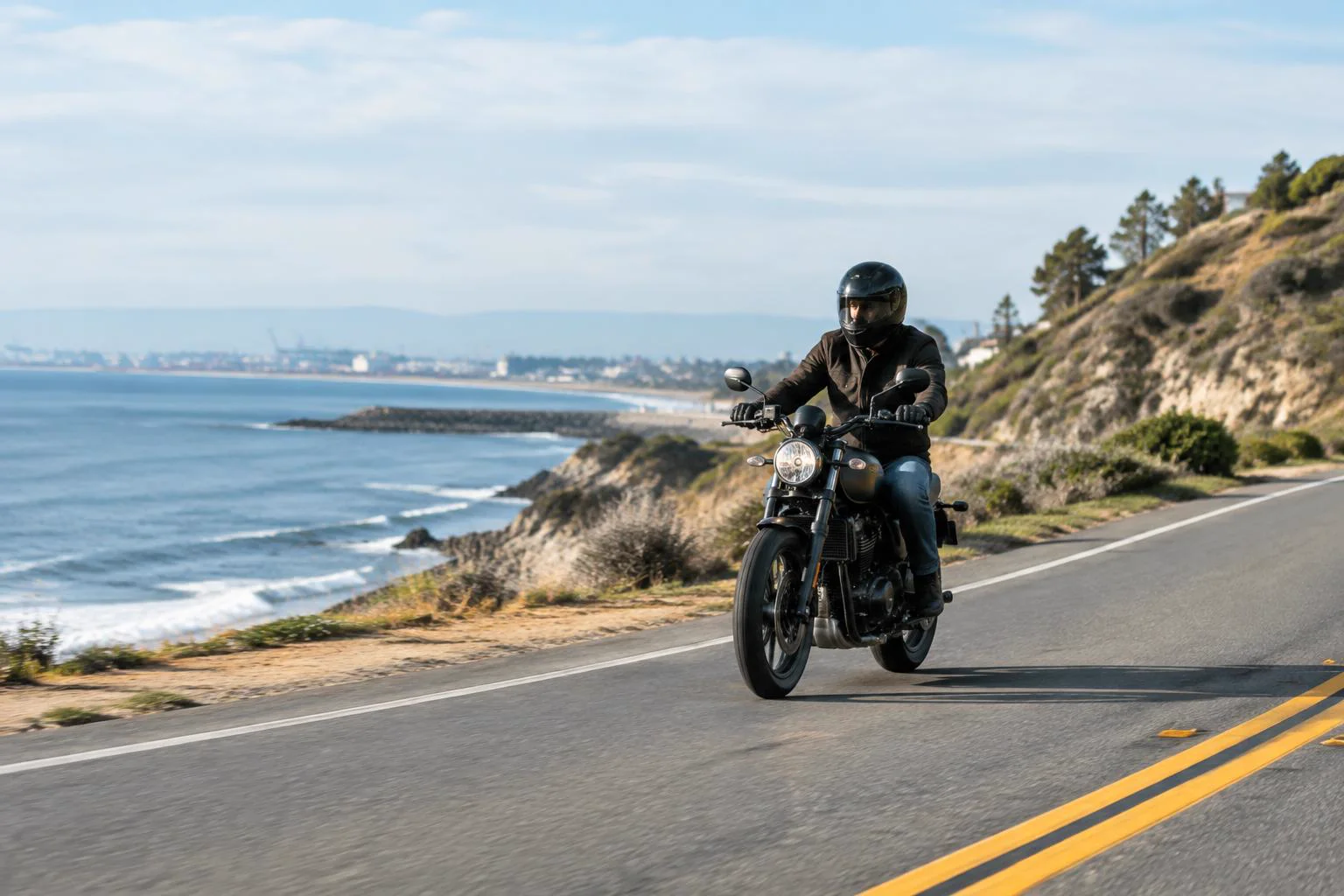 Helmeted motorcyclist riding on a coastal road near San Pedro, California